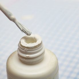 A bottle of wite-out on a table.