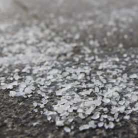 Ice melt spread across a sidewalk.