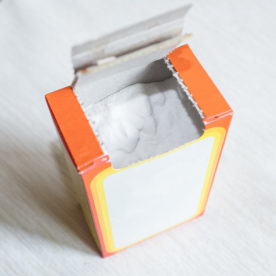 An open box of baking soda sitting on counter top.