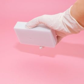 An image of someone wearing a glove using a magic eraser.