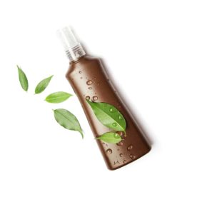 A bottle of sunless tanning products with green leaves across it.