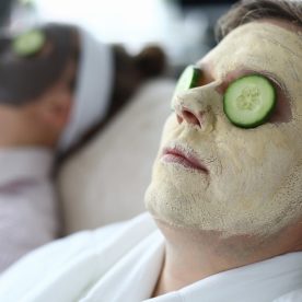 A man and a woman at a spa with face masks on.