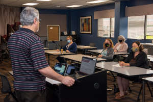 man speaking to class room of people