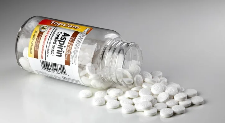 Aspirin pills spilling out of a bottle