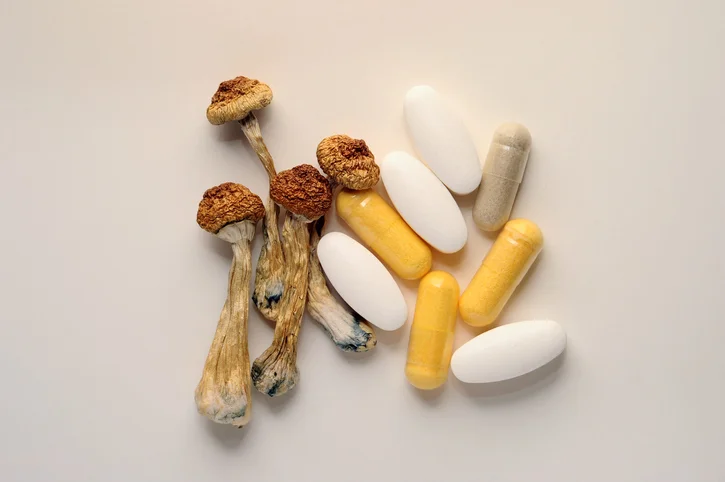 A Mix Of Vitamin Supplements And Dried Psilocybin Mushrooms.