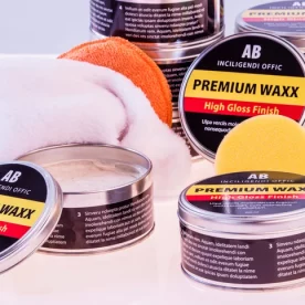 Tins of car wax beside foam applicators.