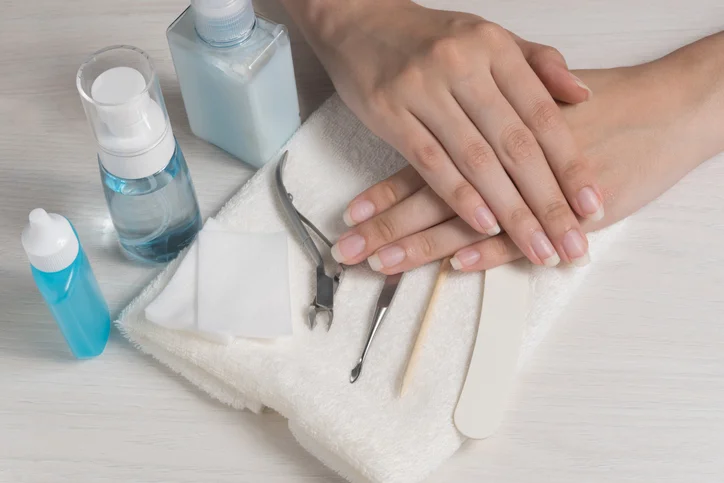 Resting hands on top of manicure tools and cloths.