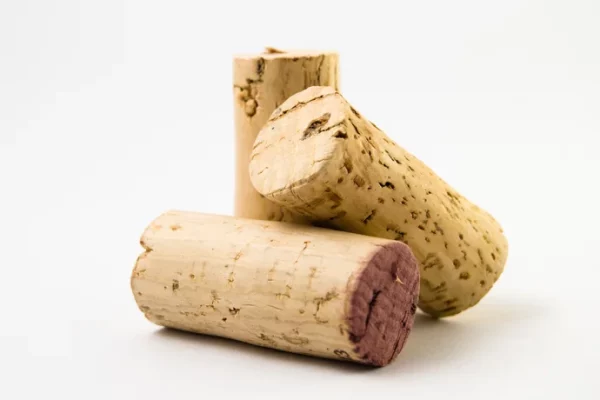 Three wine corks on top of each other on a white background.