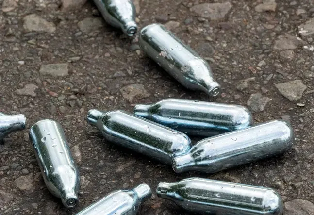 Empty whippit canisters littered on the ground.