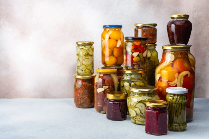 A variety of canned foods in glass jars.